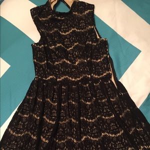 A formal dress with black mesh over a beige dress